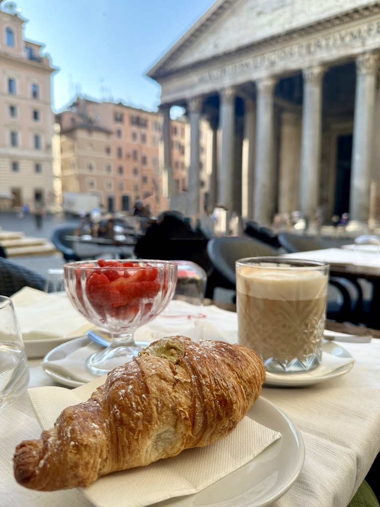 Coffee and croissants on a café table in Rome, symbolizing the beauty of slow travel mornings.