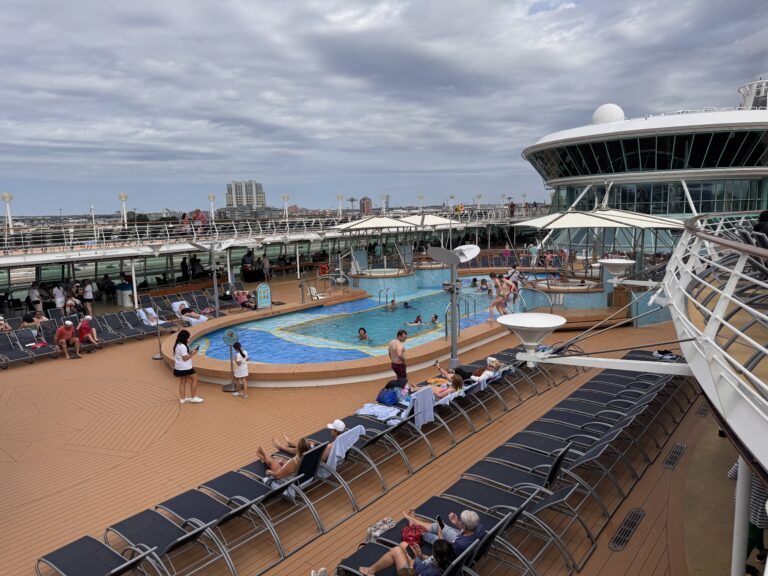 Royal Caribbean cruise pool deck with lounge chairs overlooking the Atlantic Ocean on the way from Baltimore to Bermuda, calm morning light and blue sea views.